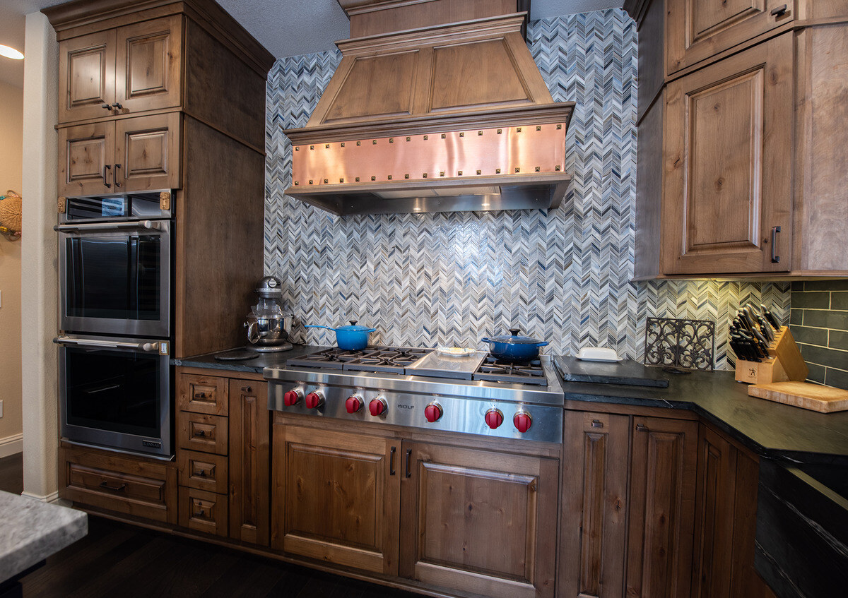 Oven and range hood with mosaic backsplash in Fresno kitchen remodel by Imagine Remodeling - Willey Ct.