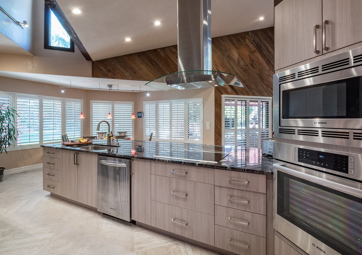 Open-concept kitchen remodel with range hood above island and double oven by Imagine Remodeling in Fresno