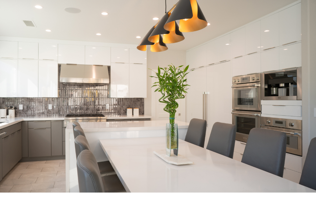 gray and white kitchen with pendant lights and large island